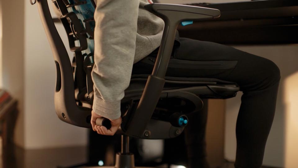 Video-Nahansicht einer Hand, die den BackFit Mechanismus an einem schwarzen Embody Gaming-Stuhl verstellt.
