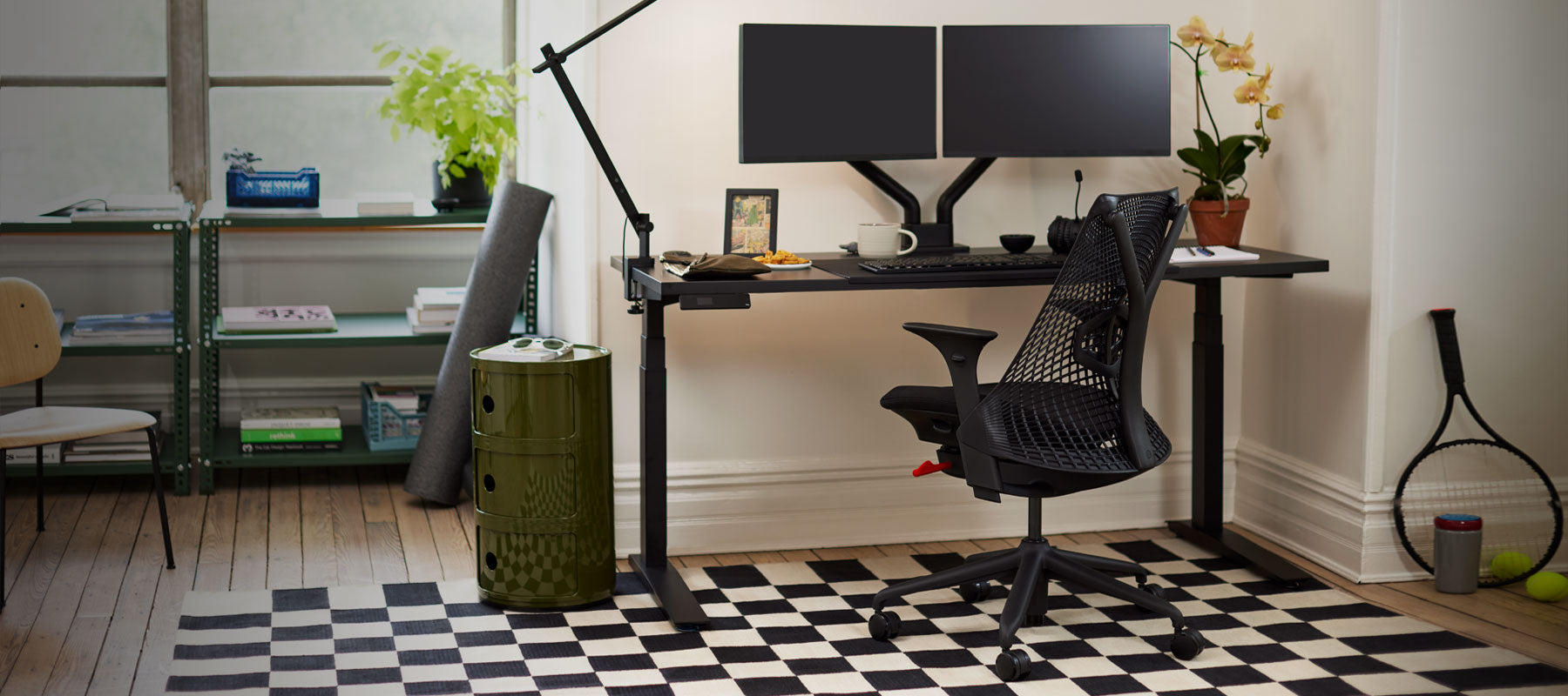 Ein schwarzer Herman Miller Sayl Gaming-Stuhl in Kombination mit einem schwarzen Jarvis Steh-Sitz-Schreibtisch.