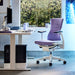 Ein Herman Miller X Logitech Embody Gaming Chair in lila Amethyst als Teil eines Gaming-Setups.
